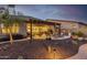 Inviting backyard with covered patio, outdoor kitchen, desert landscaping, and ambient lighting at 6929 E Quill St, Mesa, AZ 85207