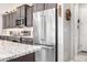 Bright, stainless steel refrigerator complements the kitchen's modern design and granite countertop at 6929 E Quill St, Mesa, AZ 85207