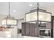 Elegant pendant lights illuminate the gourmet kitchen area, enhancing its sophisticated design at 6929 E Quill St, Mesa, AZ 85207