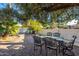 Secluded backyard patio with stylish table and chairs surrounded by lush greenery for outdoor dining and relaxation at 6941 W Voltaire Ave, Peoria, AZ 85381