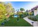 Lush backyard featuring a sparkling pool, mature trees, manicured landscaping, and stone walkways at 6941 W Voltaire Ave, Peoria, AZ 85381