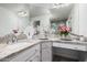 Bathroom featuring double sinks with granite countertops, elegant fixtures, and a vanity area with ample storage at 6941 W Voltaire Ave, Peoria, AZ 85381