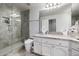 Bathroom featuring a walk-in shower with glass enclosure, white cabinetry, and a stylish granite countertop at 6941 W Voltaire Ave, Peoria, AZ 85381