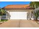 Frontal view of two car garage door, concrete drive way, and terracotta-colored roof at 6941 W Voltaire Ave, Peoria, AZ 85381