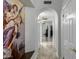 Hallway with white walls and marble flooring, featuring an arched entryway and decorative art at 6941 W Voltaire Ave, Peoria, AZ 85381