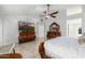 Main bedroom with ceiling fan, tiled floor, and stylish furnishings including a large TV, dresser, and mirror at 6941 W Voltaire Ave, Peoria, AZ 85381