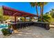 Outdoor bar with ample seating surrounded by lush landscaping, perfect for entertaining guests by the pool at 6941 W Voltaire Ave, Peoria, AZ 85381
