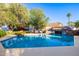 Stunning pool with a rock waterfall feature and comfortable seating, creating a serene backyard oasis at 6941 W Voltaire Ave, Peoria, AZ 85381