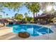 Lush backyard pool area with rock waterfall and comfortable seating perfect for relaxation and outdoor fun at 6941 W Voltaire Ave, Peoria, AZ 85381