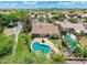 Aerial view of a home with a kidney-shaped pool, stone patio, and lush landscaping in a golf course community at 7734 E Monica Dr, Scottsdale, AZ 85255