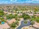 Wide aerial view showcases homes, landscaping, and a golf course under a beautiful blue sky with mountain views at 7734 E Monica Dr, Scottsdale, AZ 85255