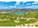 Aerial view showcases a picturesque golf course, lake, and desert community at 7734 E Monica Dr, Scottsdale, AZ 85255