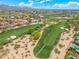 A wide aerial view features a golf course surrounded by homes, desert landscaping, mountains, and city views at 7734 E Monica Dr, Scottsdale, AZ 85255