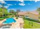 A serene backyard featuring a sparkling pool, stone patio, lush landscaping, and a view of the home's rear exterior at 7734 E Monica Dr, Scottsdale, AZ 85255