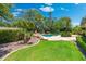 Spacious backyard features a well-maintained lawn, mature trees, and a serene pool area at 7734 E Monica Dr, Scottsdale, AZ 85255