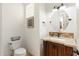 This half bathroom features a designer vanity, granite countertop, and stone mosaic backsplash at 7734 E Monica Dr, Scottsdale, AZ 85255