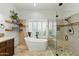 Bathroom with a freestanding tub, glass-enclosed shower, and tiled walls at 7734 E Monica Dr, Scottsdale, AZ 85255