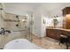 Bathroom featuring a soaking tub, a glass shower, and custom cabinets at 7734 E Monica Dr, Scottsdale, AZ 85255