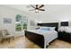 Bedroom with travertine floors, a ceiling fan, and a large window with white shutters at 7734 E Monica Dr, Scottsdale, AZ 85255