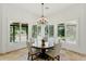 Bright breakfast nook featuring a round wood table, chandelier, and windows with views of the backyard at 7734 E Monica Dr, Scottsdale, AZ 85255