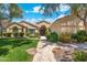 Charming single-story home featuring a lush green lawn and a stone walkway leading to the front door at 7734 E Monica Dr, Scottsdale, AZ 85255
