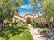 Attractive single-story home with well-maintained landscaping, mature trees, and a welcoming front entrance at 7734 E Monica Dr, Scottsdale, AZ 85255