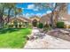 Charming single-story home with a well-manicured lawn, stone walkway, mature trees, and a welcoming front entrance at 7734 E Monica Dr, Scottsdale, AZ 85255