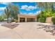 Attached three-car garage with a spacious driveway and desert landscaping enhancing the property's curb appeal at 7734 E Monica Dr, Scottsdale, AZ 85255