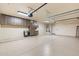 Bright garage with epoxy floors, a water heater, storage cabinets and two overhead doors at 7734 E Monica Dr, Scottsdale, AZ 85255