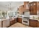 Modern kitchen with stainless steel appliances, stone countertops and island with seating and pendant lights at 7734 E Monica Dr, Scottsdale, AZ 85255