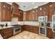 Gourmet kitchen with stainless steel appliances, custom hood, and beautiful tile backsplash for a modern look at 7734 E Monica Dr, Scottsdale, AZ 85255