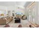 Bright living room with tan sofa, large windows, and a modern entertainment center with golf on TV at 7734 E Monica Dr, Scottsdale, AZ 85255