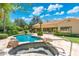 Backyard pool with integrated spa, rocks, and a patio, perfect for relaxation at 7734 E Monica Dr, Scottsdale, AZ 85255