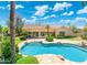 A gorgeous sparkling pool and travertine patio meet the lush grass and back of this single-story home at 7734 E Monica Dr, Scottsdale, AZ 85255