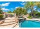 Beautiful backyard pool with a hot tub, rock features, and mature landscaping for a private and relaxing retreat at 7734 E Monica Dr, Scottsdale, AZ 85255