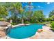 Inviting backyard pool with rock features and lush landscaping, perfect for relaxation and entertaining at 7734 E Monica Dr, Scottsdale, AZ 85255