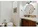 Elegant powder room with a decorative mirror, custom vanity, and unique lighting fixtures at 7734 E Monica Dr, Scottsdale, AZ 85255