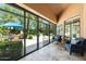 Charming sunroom with travertine floors, glass doors to backyard, and comfortable seating at 7734 E Monica Dr, Scottsdale, AZ 85255