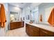 Bathroom featuring double sinks, framed mirrors, wood cabinets, and natural light at 7854 W Tether Trl, Peoria, AZ 85383