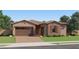 Charming single-story home with a two-car garage, brick accents, and desert landscaping at 7854 W Tether Trl, Peoria, AZ 85383