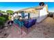 Relaxing backyard patio with comfortable seating, a fire pit, and a charming tiki umbrella at 7916 E Naranja Ave, Mesa, AZ 85209