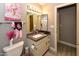 Cozy bathroom features a vanity with storage, decorative mirror, and playful decor at 7916 E Naranja Ave, Mesa, AZ 85209
