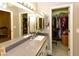 Bathroom featuring double mirrors, a white sink, and a door leading to a walk-in closet at 7916 E Naranja Ave, Mesa, AZ 85209