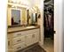 Bathroom featuring double mirrors, white cabinets, and access to a closet, combining style and functionality at 7916 E Naranja Ave, Mesa, AZ 85209