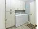 Functional laundry room with a washer, dryer, and ample storage cabinets at 7916 E Naranja Ave, Mesa, AZ 85209
