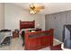 Comfortable bedroom with wood floors, ceiling fan, dark gray walls, and large wooden bed frame at 7916 E Naranja Ave, Mesa, AZ 85209