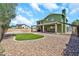 Spacious backyard with a covered patio, low maintenance rock landscaping, and green grass at 8871 W Maryland Ave, Glendale, AZ 85305