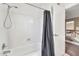 Bathroom with a shower and tub combination, a shower curtain, and a white door at 8871 W Maryland Ave, Glendale, AZ 85305