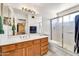 Bright bathroom featuring a shower, toilet, and vanity with a large mirror at 8871 W Maryland Ave, Glendale, AZ 85305