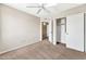 Bedroom featuring carpet, ceiling fan, closet, neutral colored walls, and a view to the hallway at 8871 W Maryland Ave, Glendale, AZ 85305